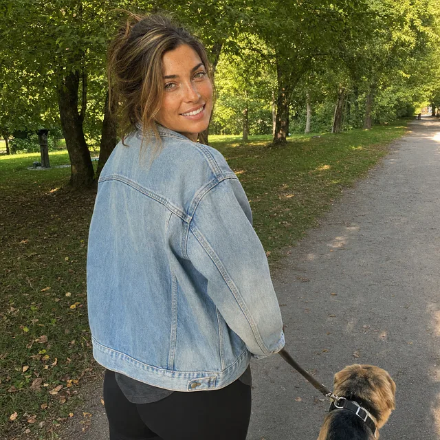 Everyday photo of a white woman walking her dog in a park